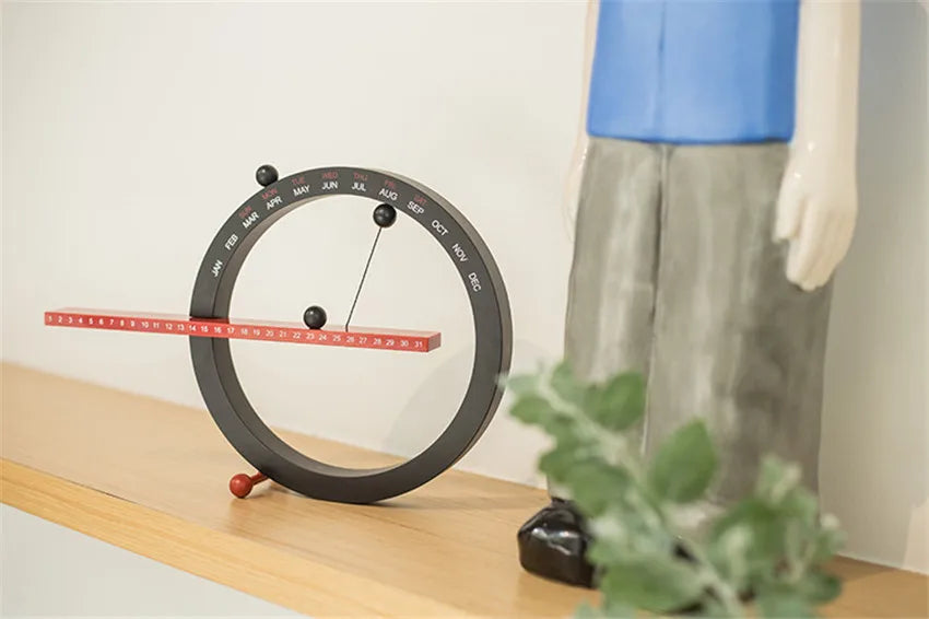 A beautiful wooden perpetual calendar displayed on a clean, minimalist office desk.