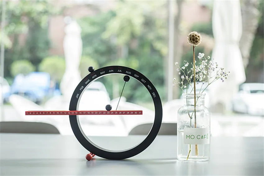 A beautiful wooden perpetual calendar displayed on a clean, minimalist office desk.