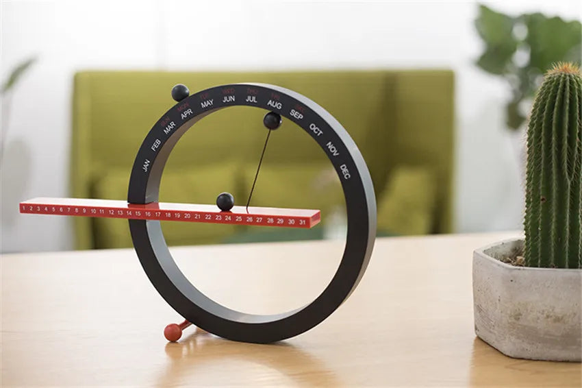 A beautiful wooden perpetual calendar displayed on a clean, minimalist office desk.