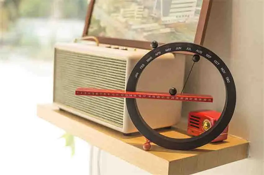 A beautiful wooden perpetual calendar displayed on a clean, minimalist office desk.