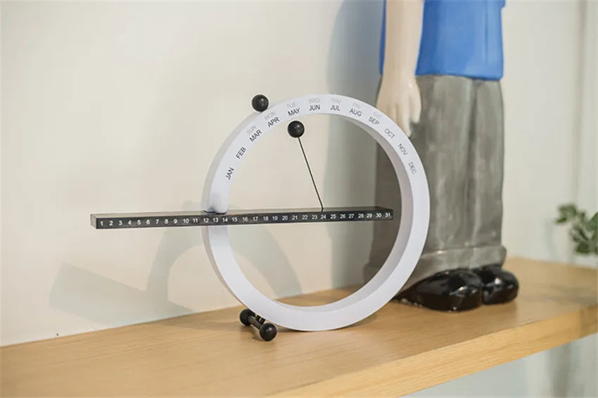 A beautiful wooden perpetual calendar displayed on a clean, minimalist office desk.