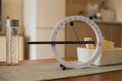A beautiful wooden perpetual calendar displayed on a clean, minimalist office desk.