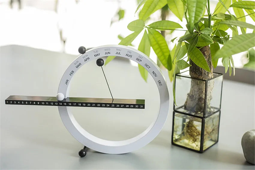 A beautiful wooden perpetual calendar displayed on a clean, minimalist office desk.