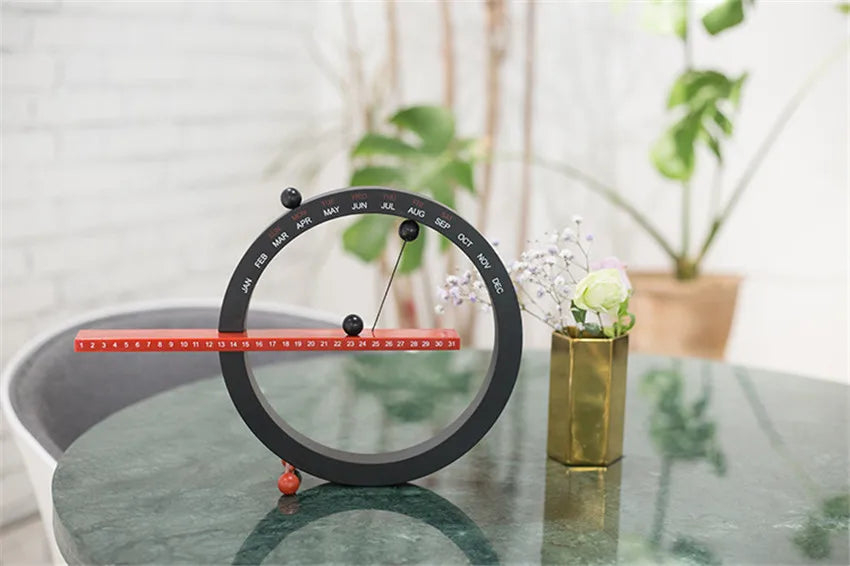 A beautiful wooden perpetual calendar displayed on a clean, minimalist office desk.