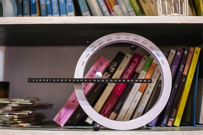 A beautiful wooden perpetual calendar displayed on a clean, minimalist office desk.