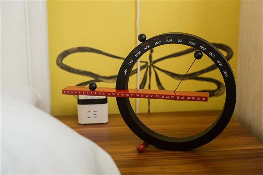 A beautiful wooden perpetual calendar displayed on a clean, minimalist office desk.