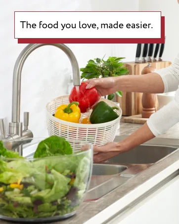 Multifunctional vegetable food cutter slicing fresh zucchini on a kitchen counter