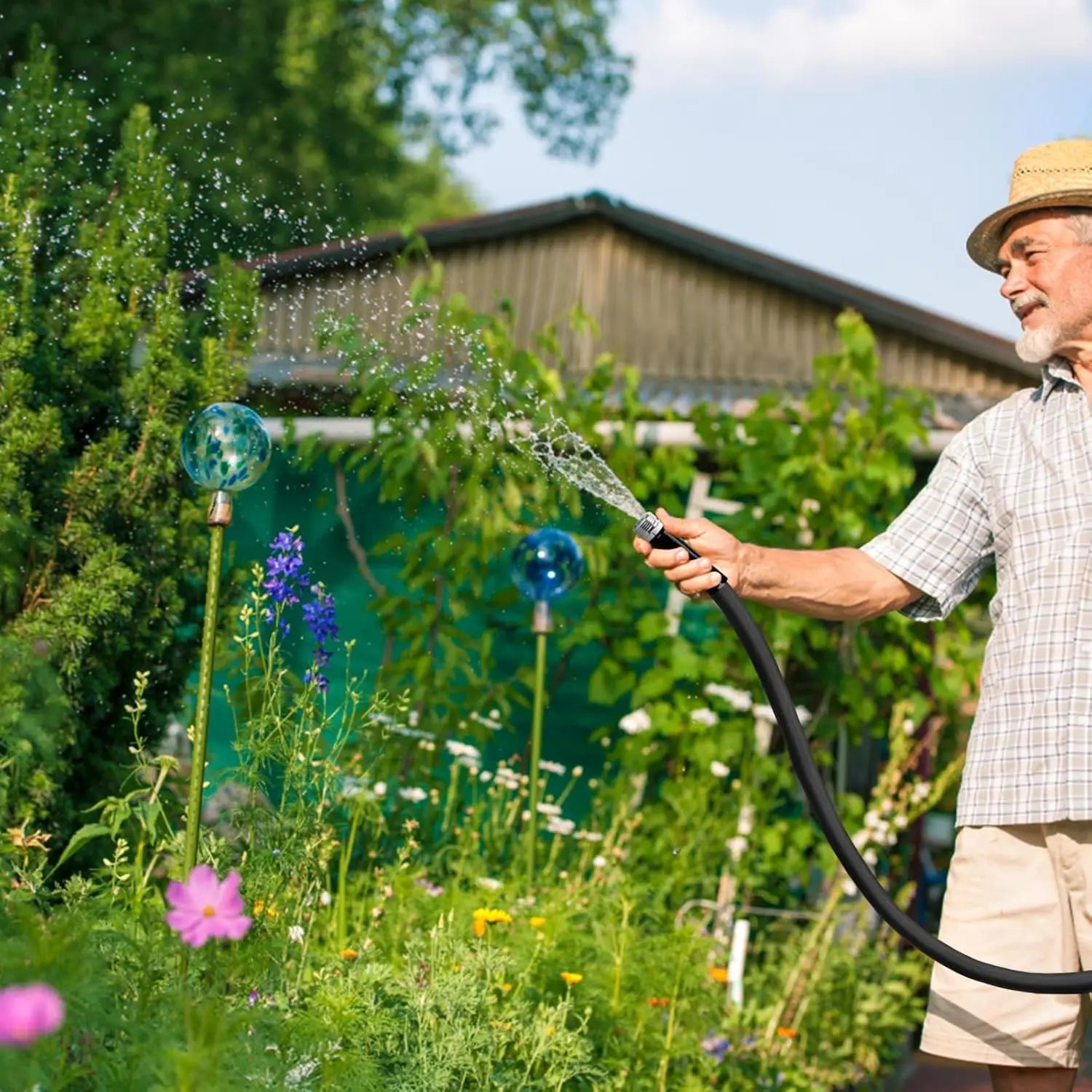 Person using a 50ft garden hose to water garden plants