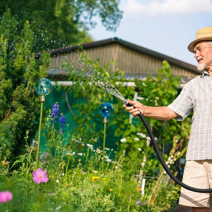 Person using a 50ft garden hose to water garden plants