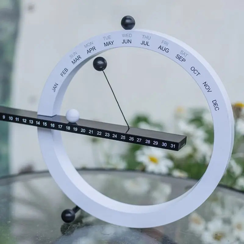 A beautiful wooden perpetual calendar displayed on a clean, minimalist office desk.