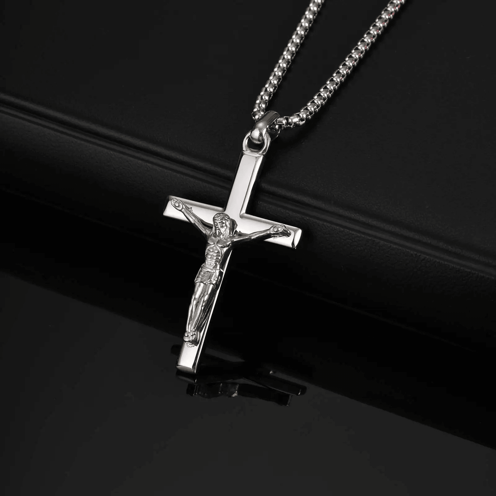 Silver crucifix pendant necklace on a black background