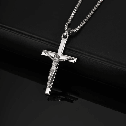Silver crucifix pendant necklace on a black background