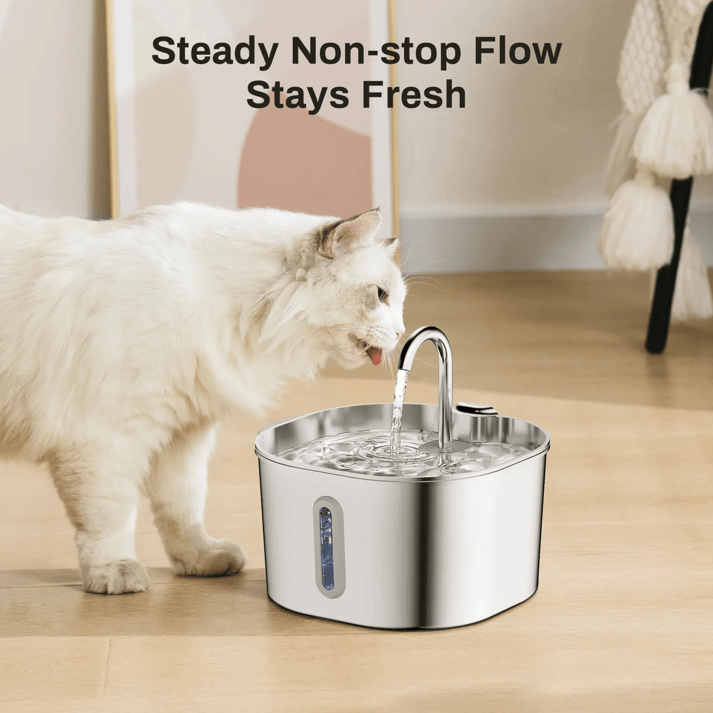Cat drinking water from a stainless steel pet fountain on a wooden floor.
