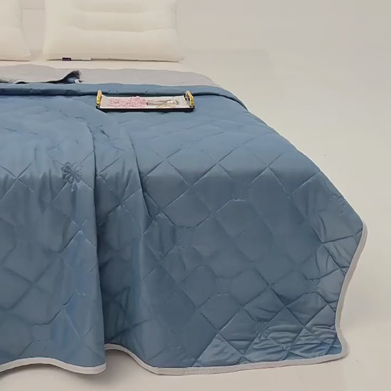 "VelmoraMart cooling comforter draped over a bed, showcasing breathable, temperature-regulating fabric for hot sleepers."