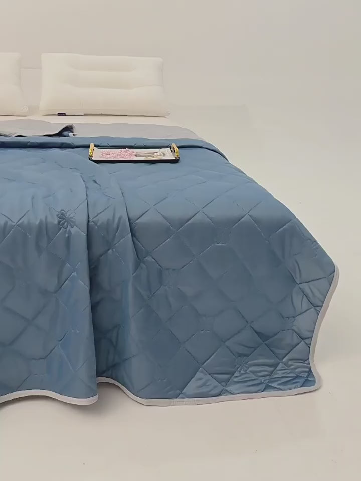 "VelmoraMart cooling comforter draped over a bed, showcasing breathable, temperature-regulating fabric for hot sleepers."