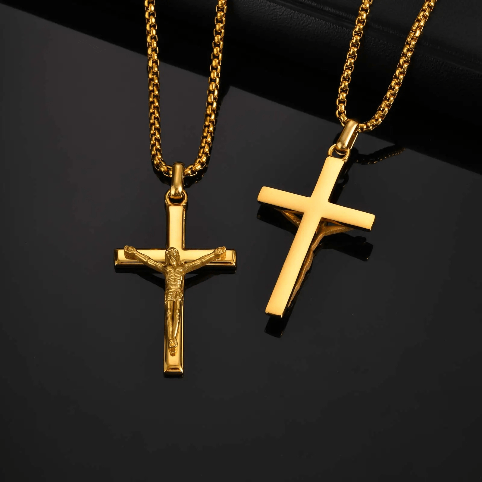 Two gold crucifix pendants on black background