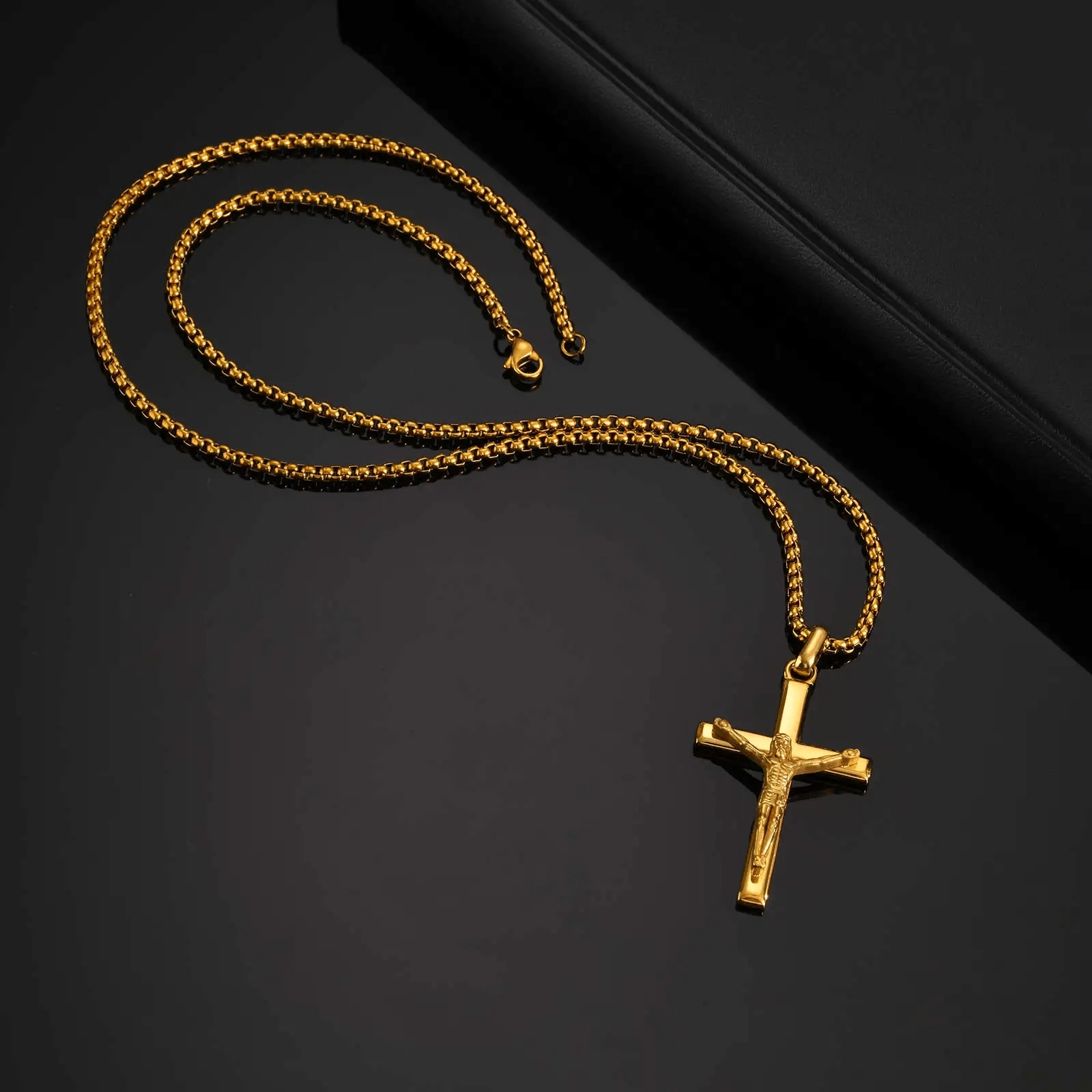 Gold necklace with a cross pendant on a black background